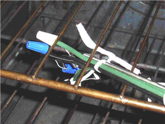 Experimental setup, detail view showing diode and temperature probe lashed together and attached to oven rack with wire ties.