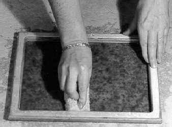 Couching the sheet of paper on absorbent cloth.