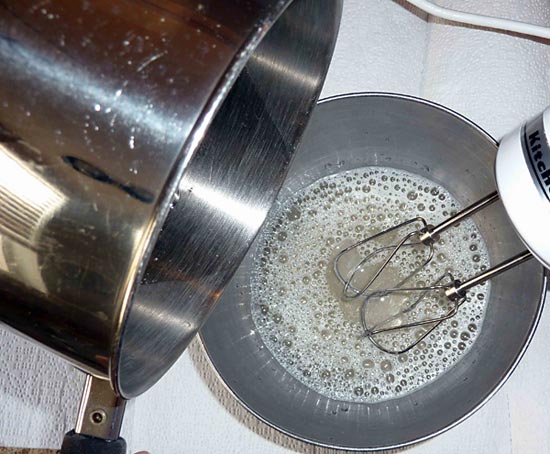 Food Science project hot syrup slowly being poured into the gelatin while the mixer is operating on low.