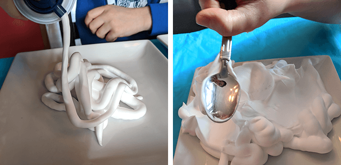 Student spraying and spreading shaving cream on a plate for paper marbling activity