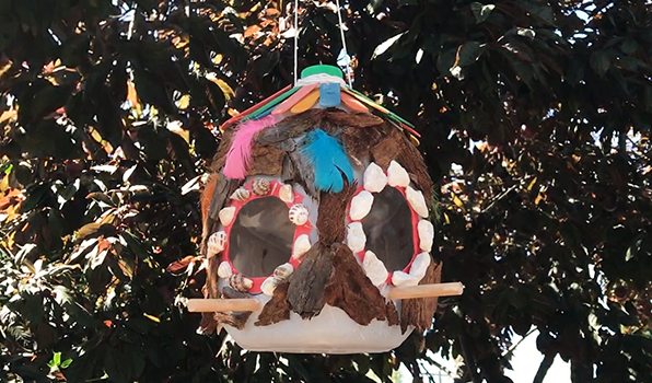 Bird feeder made from recycled plastic bottle and decorated with craft materials