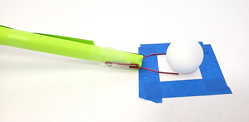 A paper tube with paper clips taped to the end to make a fork to pick up the ping pong ball 