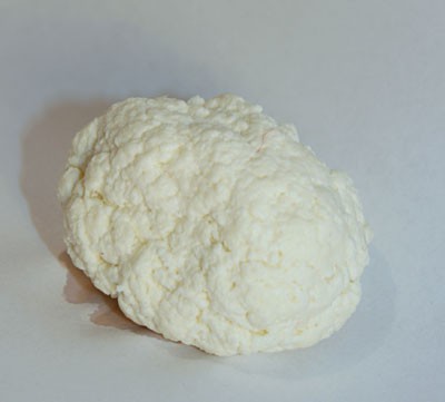 A lumpy white ball made of curds that have been squeezed of excess liquid
