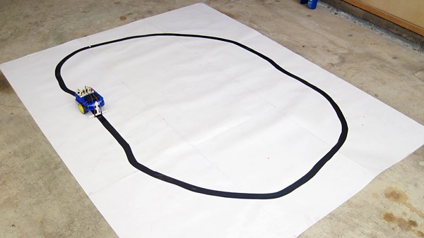 A line-following robot is placed on a sheet of white paper with a large circle drawn in black ink