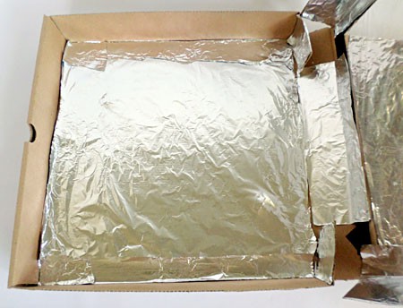 Interior of a pizza box solar oven is lined with aluminum foil