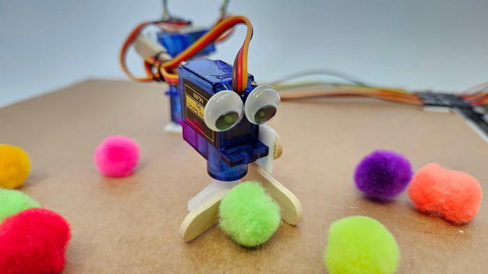 completed robotic arm gripper made out of popsicle sticks and decorated with googly eyes