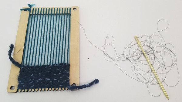 Tying end of conductive thread patch to thick yarn. 