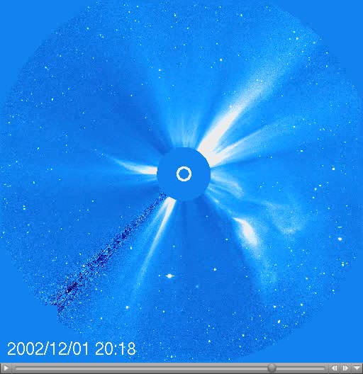 A coronagraph shows a large white flare emerging from the surface of the Sun with a timestamp of 2002/12/01 20:18