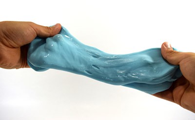 A blob of slime being stretched between two hands. 