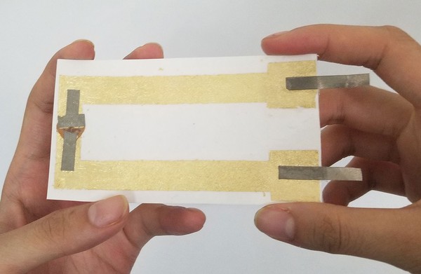 Trimmed final temporary tattoo circuit with adhesive film and backing 
