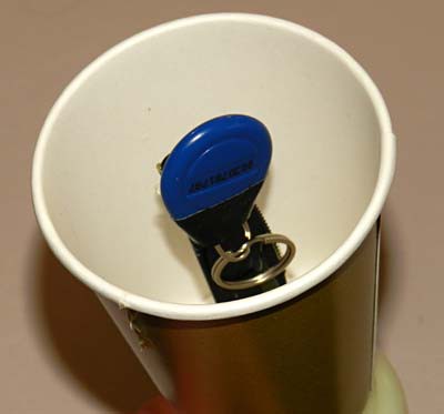 A RFID tag is taped to the head of a plastic knife that is coming up through the bottom of a paper cup