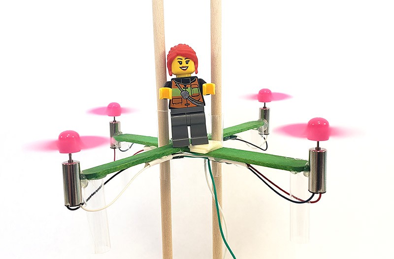  A LEGO mini figure riding on a popsicle stick drone.  