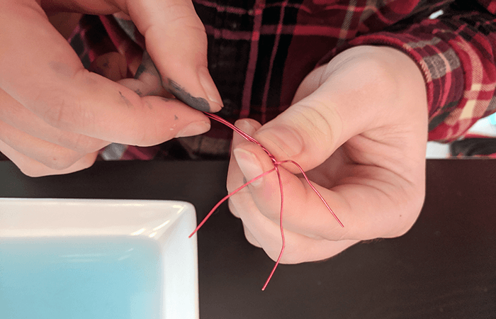 Student twisting wire to make a water strider body
