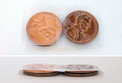 Two stacks of two pennies are wrapped in tape