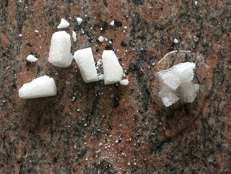 Sugar cube broken down into pieces through chemical and physical weathering