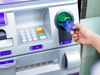person's hand entering card in ATM