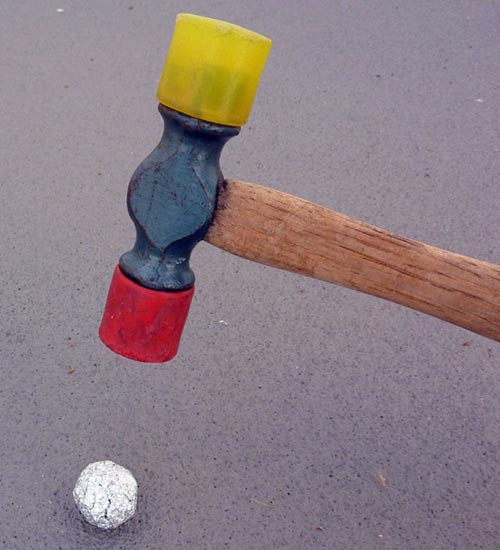A rubber mallet is used to compact an aluminum foil ball