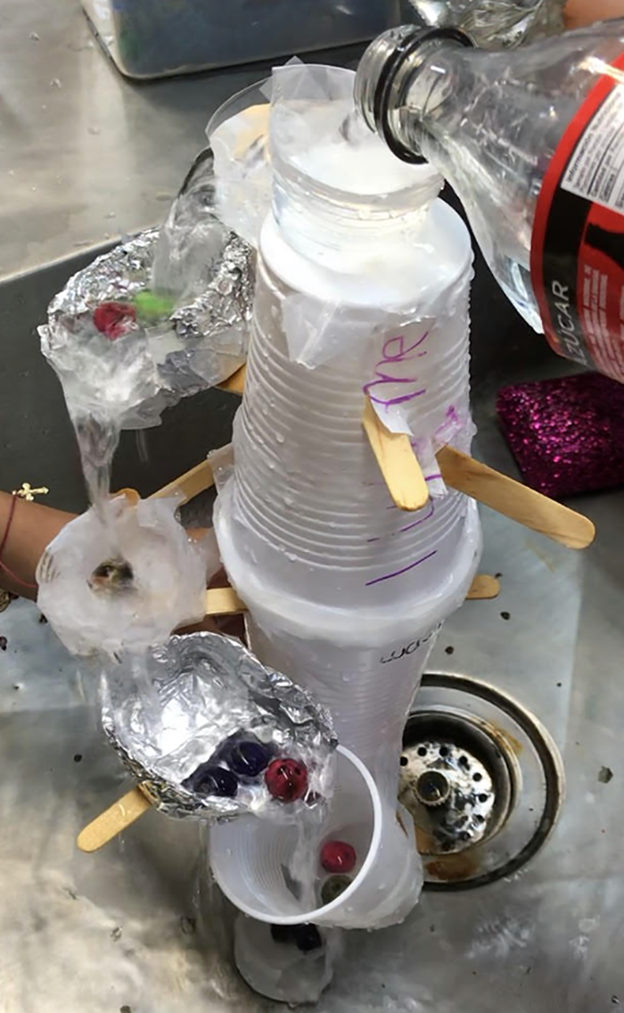 A terraced waterfall made from plastic cups, aluminum foil, popsicle sticks and tape