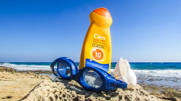 Sunscreen bottle on sand