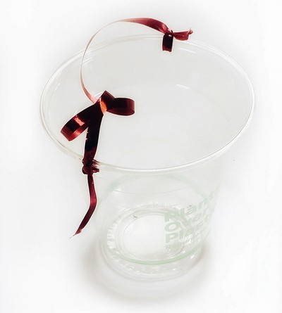 A cup to which a string is knotted. The string serves as a handle.  