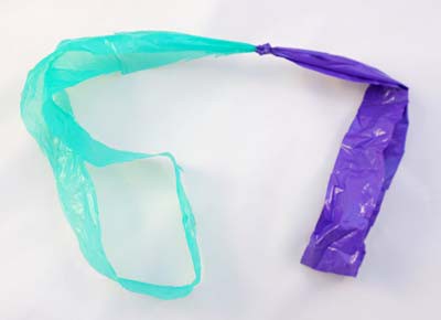 Two plastic bag rings are knotted together to create a longer piece of plastic