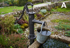 Photo of a bucket on the end of a spout for a water pump