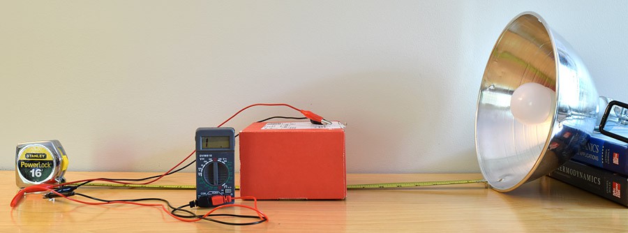 A large lamp points towards a photoresistor that is connected to a multimeter