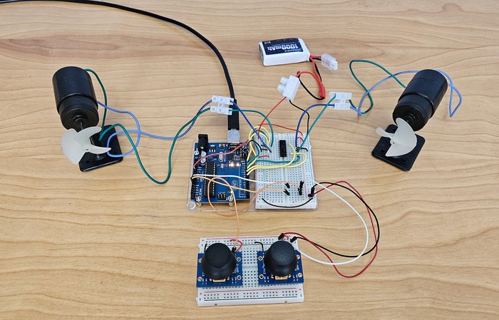 Picture of the ROV circuit with Arduino, two breadboards, two thrusters, and lithium battery. 