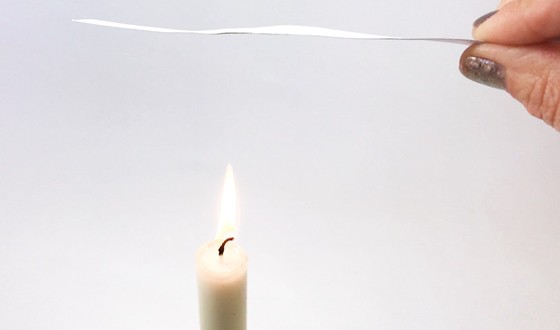 Paper strip held about 2 inches above a candle flame.