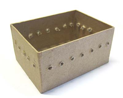 Evenly spaced holes are drilled at an even height around a paper mache box