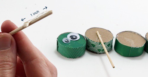 Glue is put on the top 1 inch of skewer and glued to the back side of the caterpillar's body part.