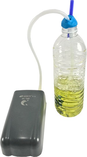 An aquarium pump is used to aeriate indicator solution in a plastic bottle
