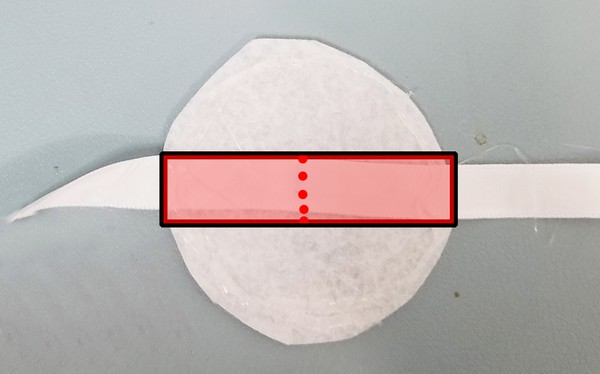 Midpoint of ribbon indicated hot glued onto felt piece B. 