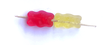 Two pieces of candy on a single toothpick. These represent a DNA base pair.