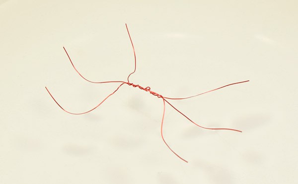 Three copper wires twisted together at the center form a bug with six legs
