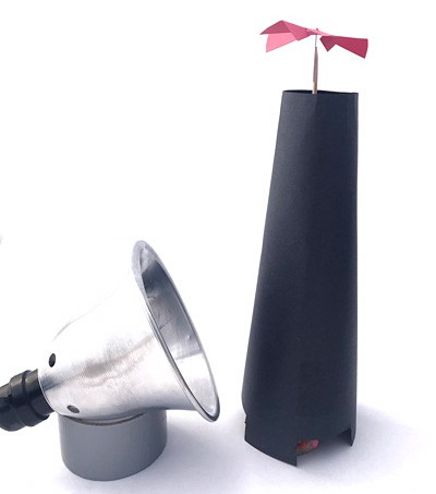 A small lamp next to a homemade updraft tower