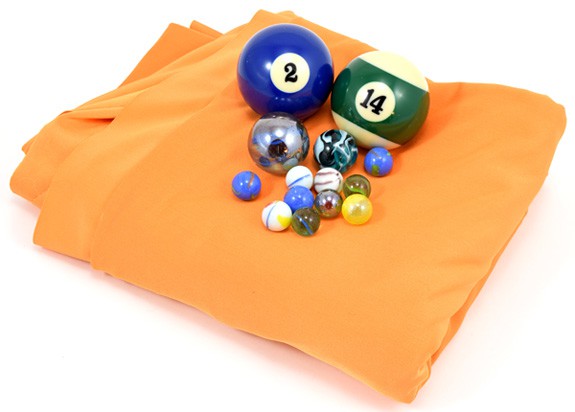 Folded orange fabric, two billiard balls, two large shooter marbles and nine regular glass marbles