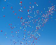 Hundred of balloons float into the sky