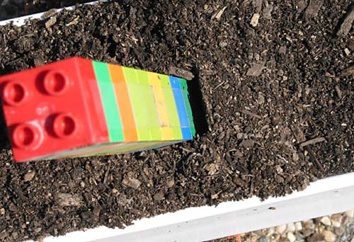 A small gap forms between the side of a model tower and its soil foundation