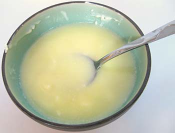 A spoon sits in a bowl of melted butter