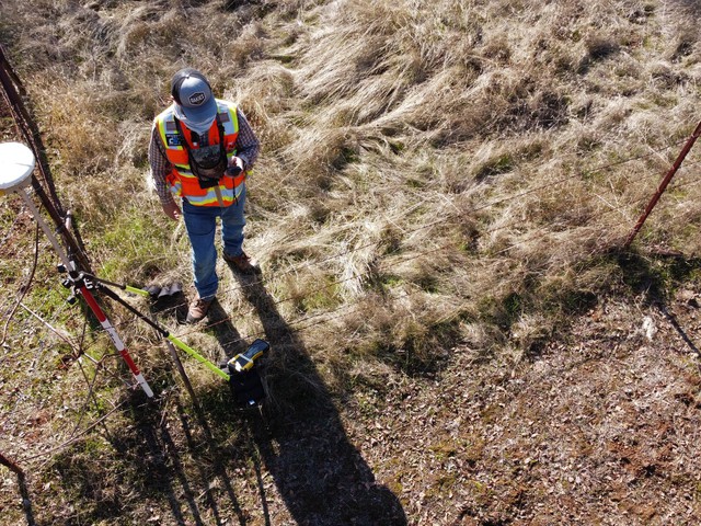 man in field with GPS signal device