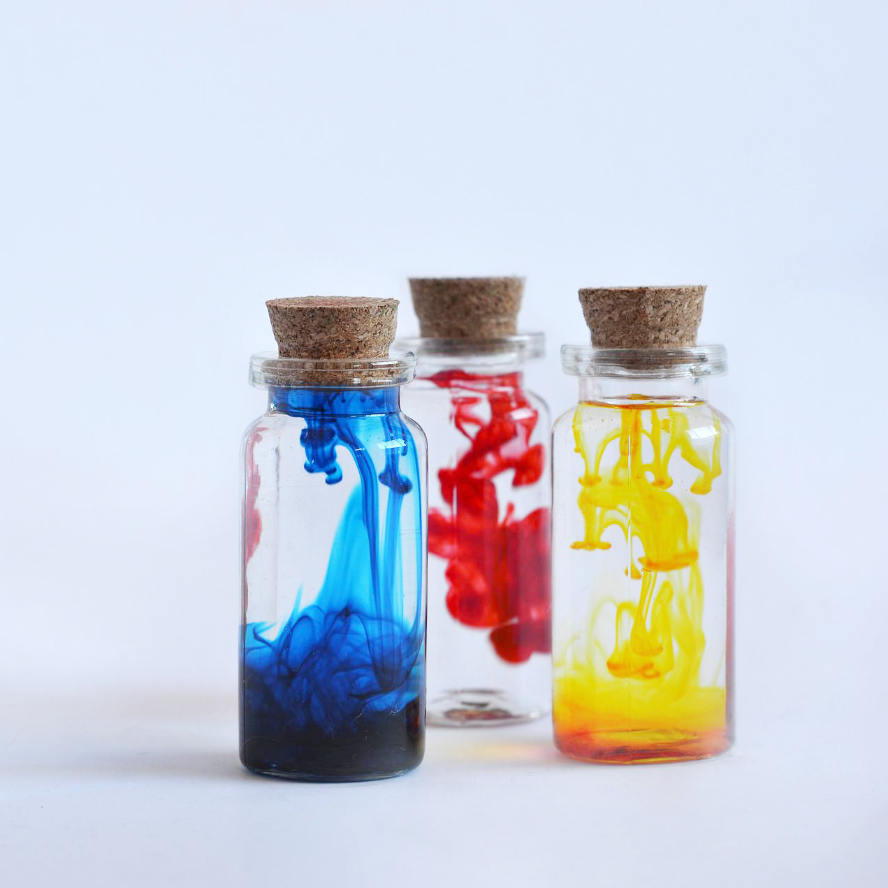 Three small glass bottles with colored liquid inside for National Chemistry Week