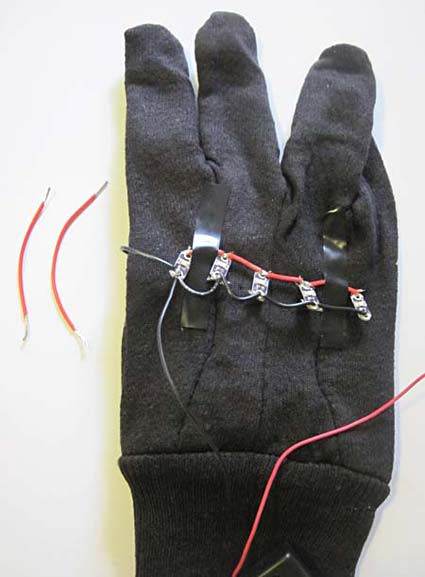 Two red wires next to an LED strip taped to a glove