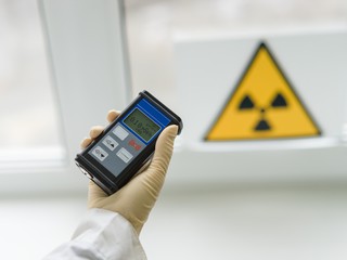 scientists checking a dosimeter to measure radiation levels