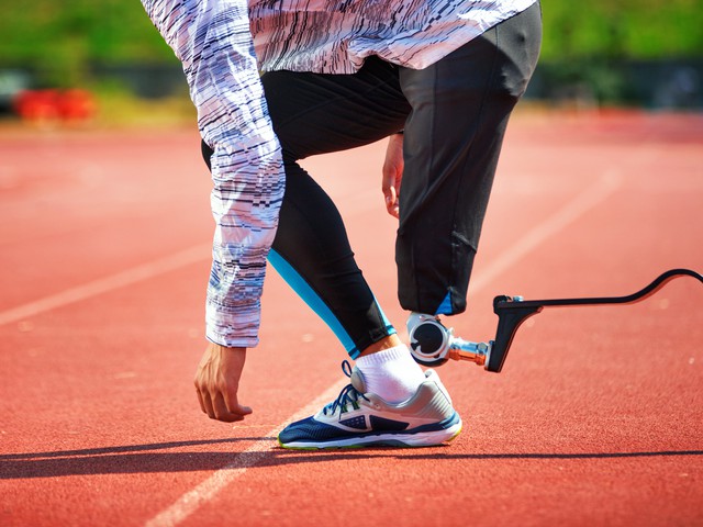 Runner on track with carbon fiber blade prosthetic ready for start
