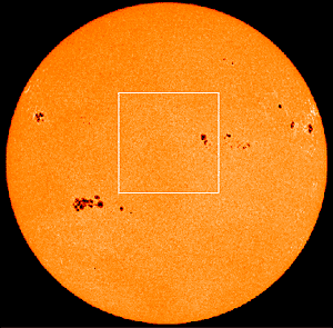 Photo of the Sun with dark sunspots visible across the surface