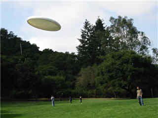 Photo of a frisbee gliding through the air at a park