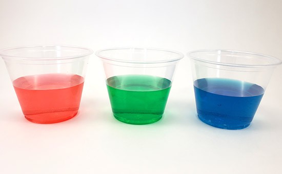 Three cups filled with red, green, and blue liquid