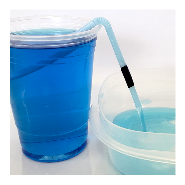 Glass of liquid with straw siphon moving water into a container - Awesome Summer Science Experiments