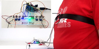 A person wearing straps around their chest and stomach that are connected with wires to a circuit with an Arduino and LEDs Science Project